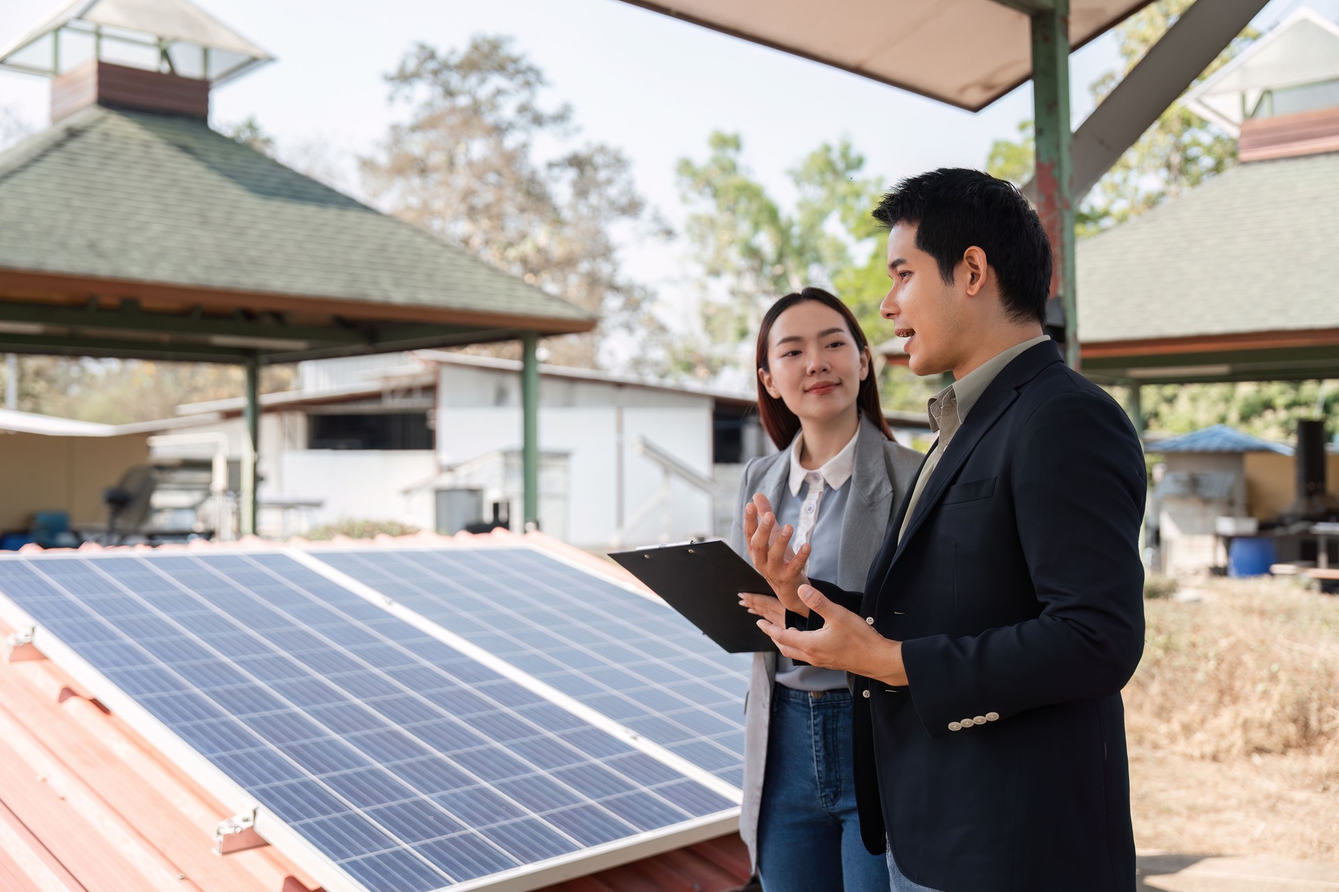 Sustainable business collaboration. Business professionals discussing renewable energy solutions by solar panels.